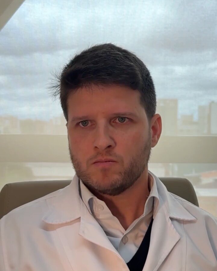 Dr. Luiz Müller Avila de jaleco, gravando um vídeo sobre artrodese